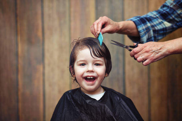 A little boy is trimmed in the hairdresser's bright emotions on his face